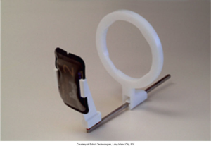 A dental beam alignment device with a white circular ring and a holder for a PSP digital sensor used in bite-wing X-ray imaging, courtesy of Schick Technologies, Long Island City, NY.