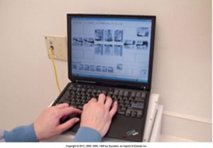 Hands typing on a laptop which displays multiple dental X-ray images for examination or analysis.