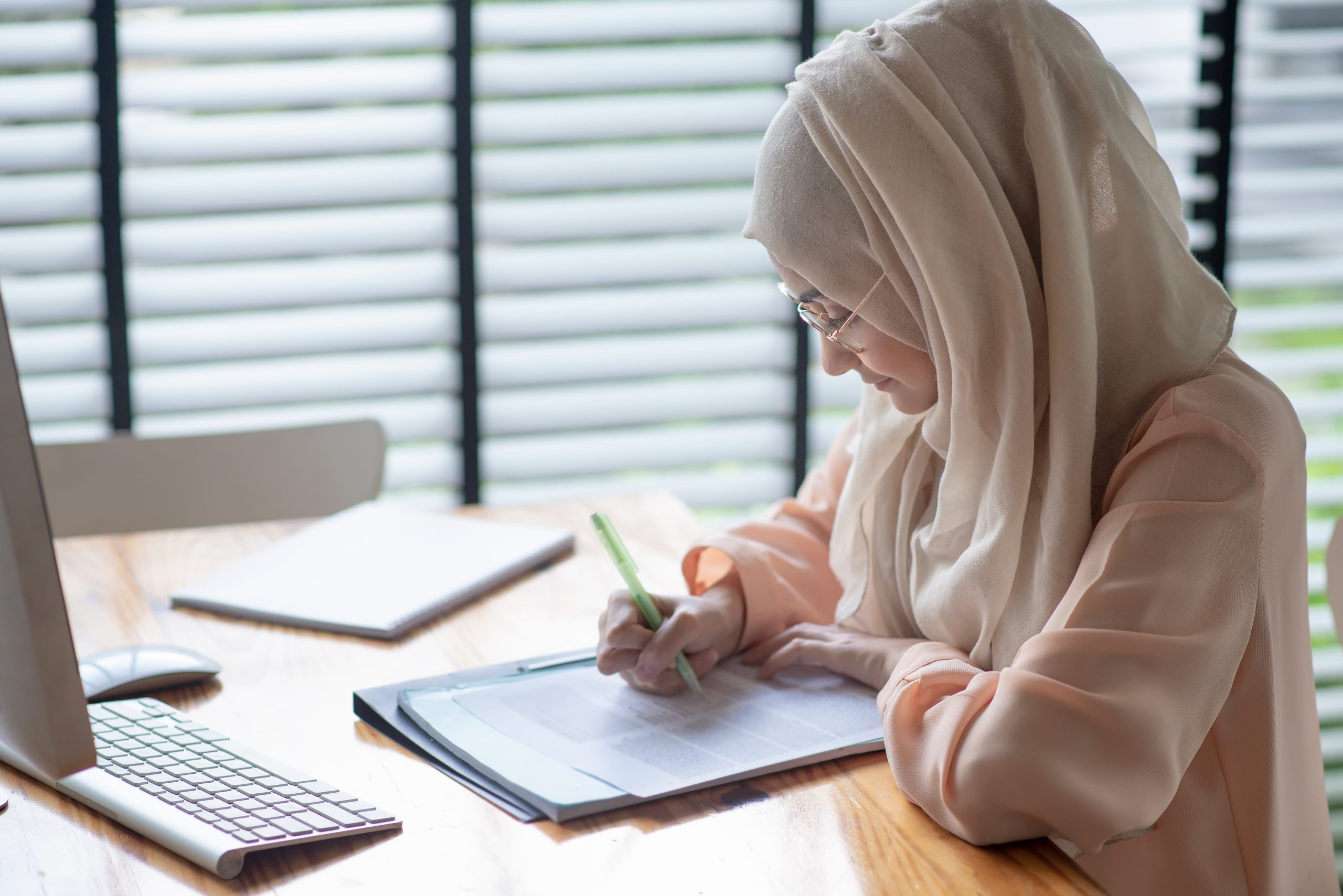 Decorative photograph of a student studying at a desk.