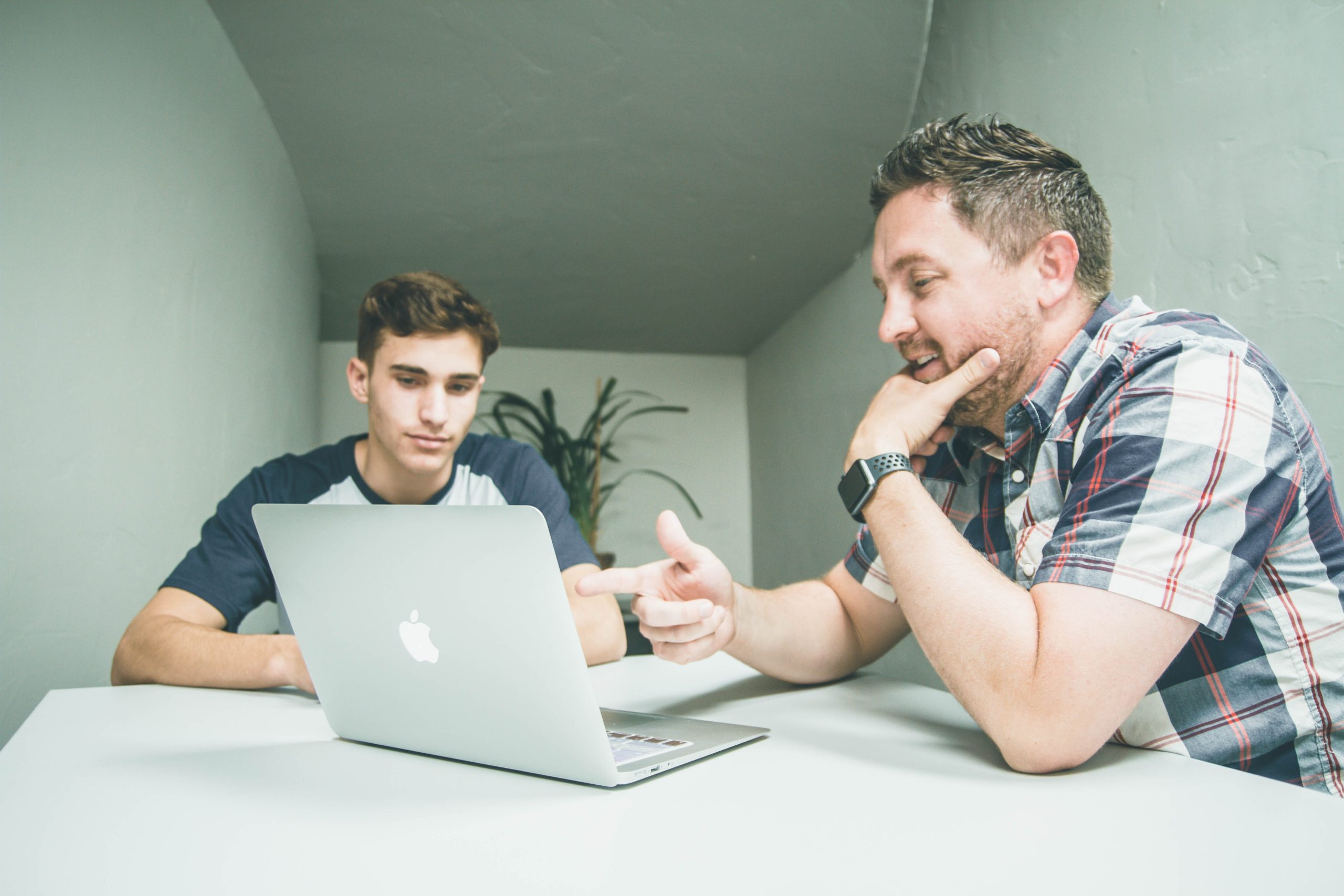 Decorative image of a professor and student looking at a laptop screen together.