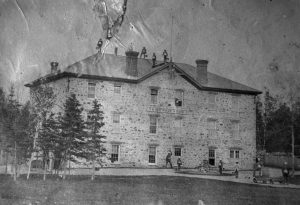 Shingwauk Home building with boys on roof and in front of building