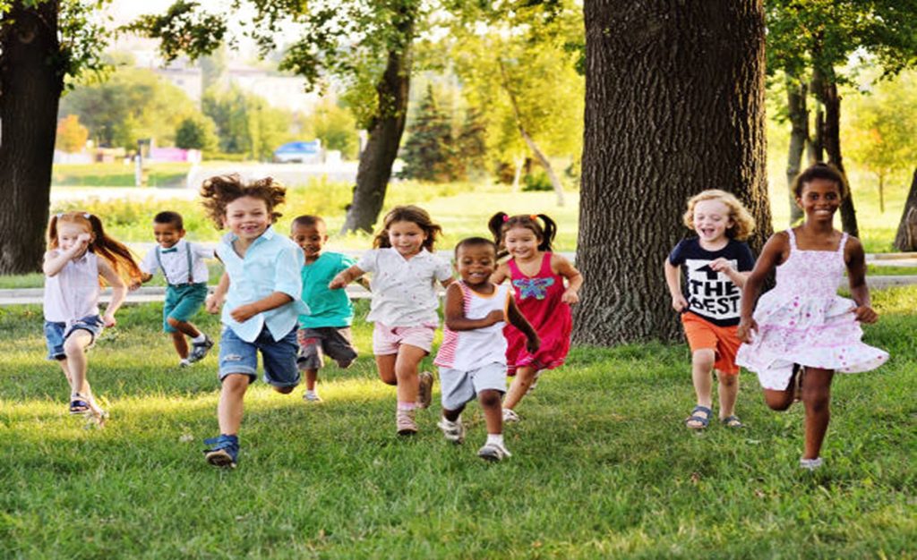 Young children running in a field.