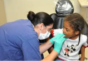 A dentist checking a child's teeth.