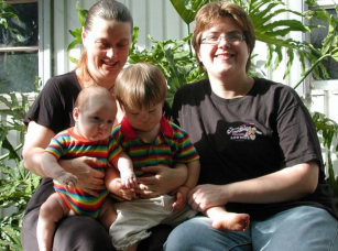 Two women sitting outside with two children on their laps