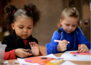 Photo of children colouring with markers.