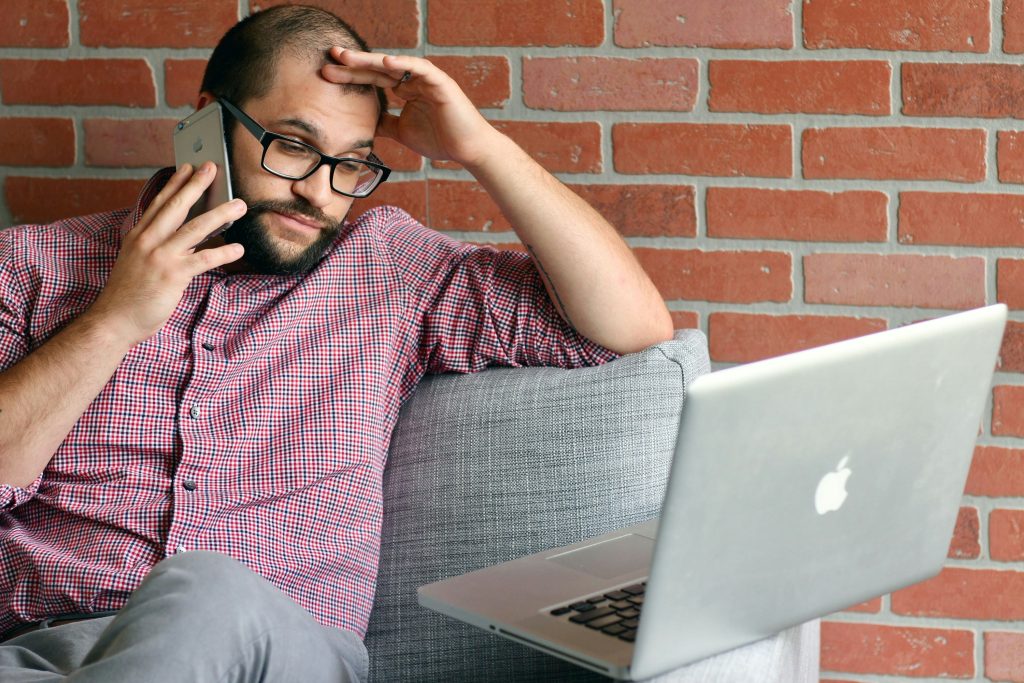 stressed worker on the phone looking at a computer