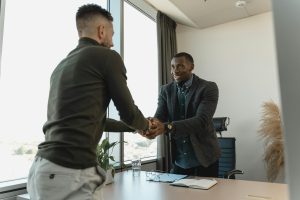 A job candidate and an employer are shaking hands following an interview.