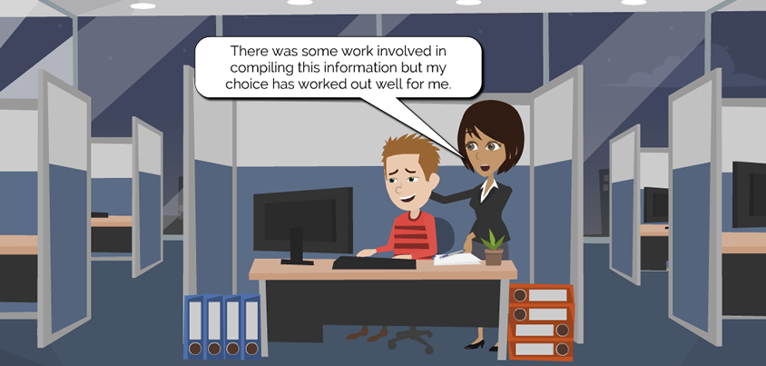 At a desk in a cubicle, Jane Career stands behind another person who is sitting at a desk and working on their computer. Jane says, “There was some work involved in compiling this information but my choice has worked out well for me.”