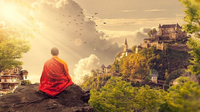 painting of a Buddist monk sitting in front of a temple in the distance at sunrise