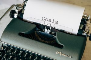 Type writer with a piece of paper that says goal