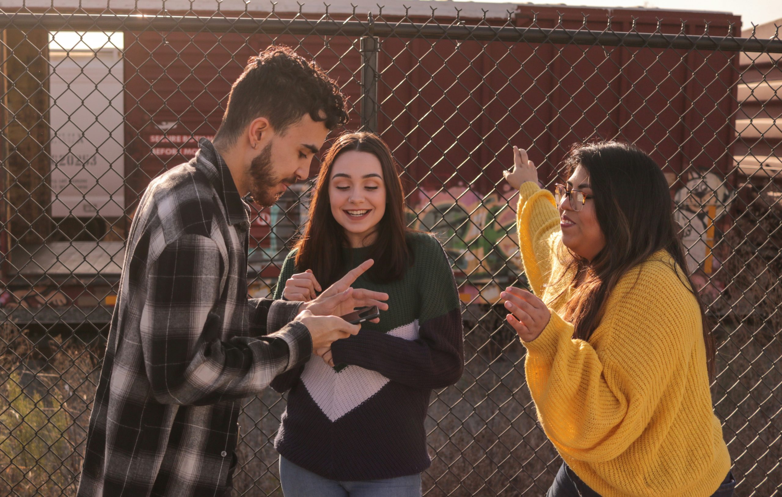 Photo of three teenagers using a smartphone together.