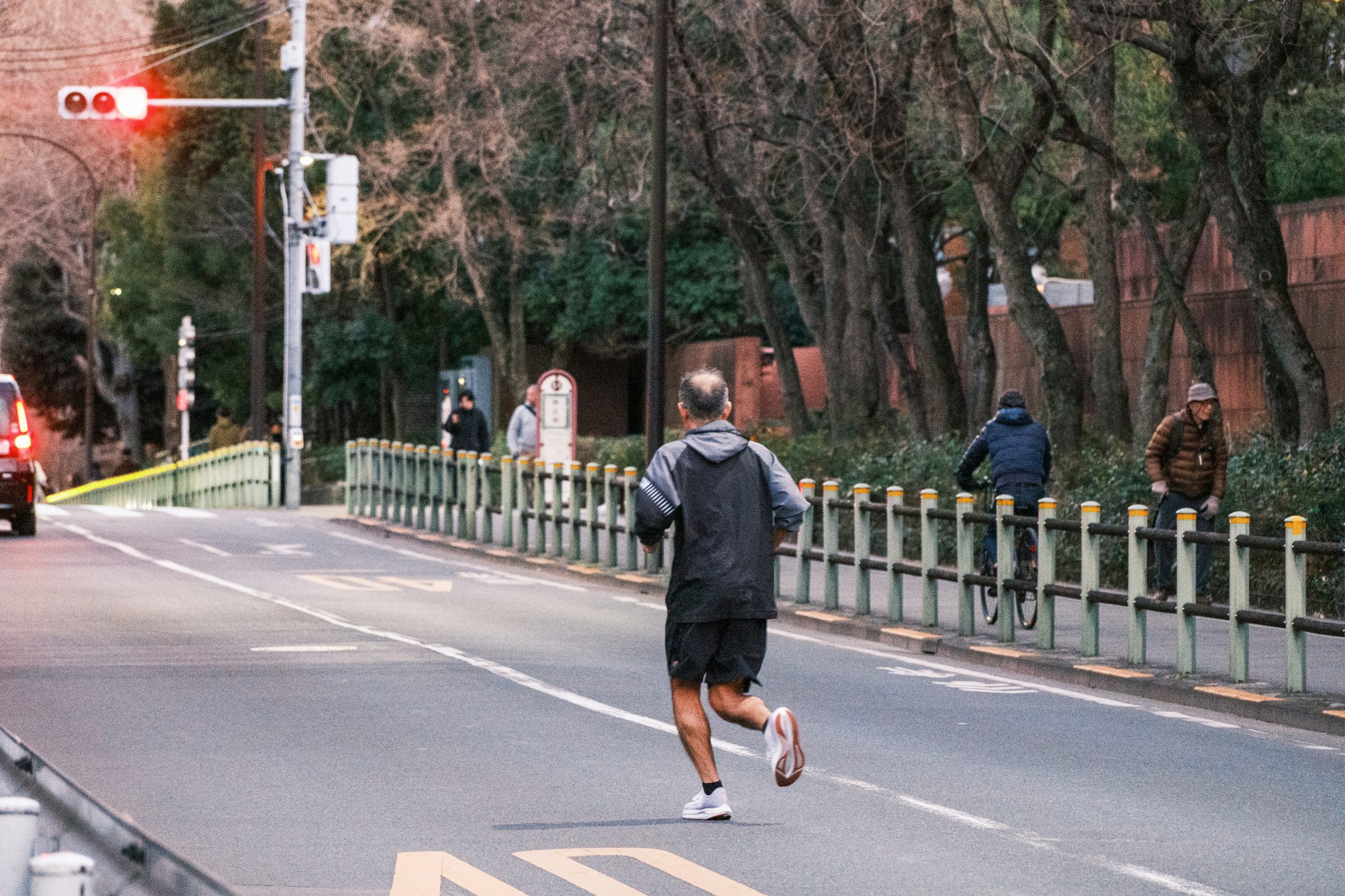Image of a man running down a street toward a traffic light.