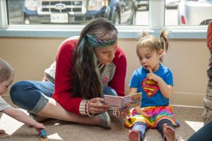 ECE worker reading a book to a child.