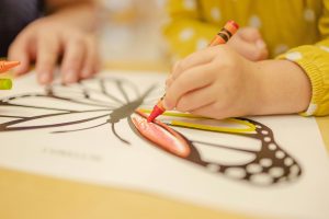 A child colouring a butterfly.