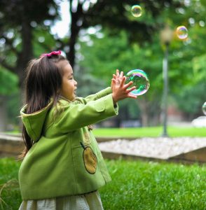 A toddler playing with bubbles.