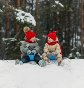 Two toddlers playing in the snow.