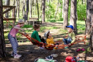 Children playing outside on a hammock.