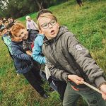 A photo of a group of children pulling a rope together in a game of tug-of-war