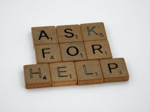 Scrabble tiles that spell out the statement, "Ask for help."