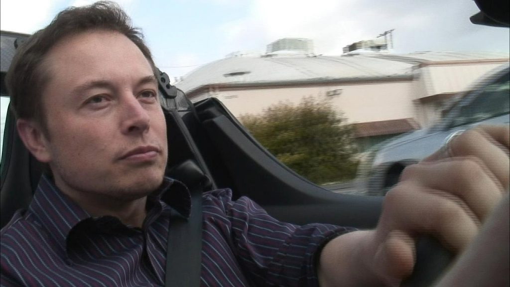 Photo of Elon Musk driving a car.