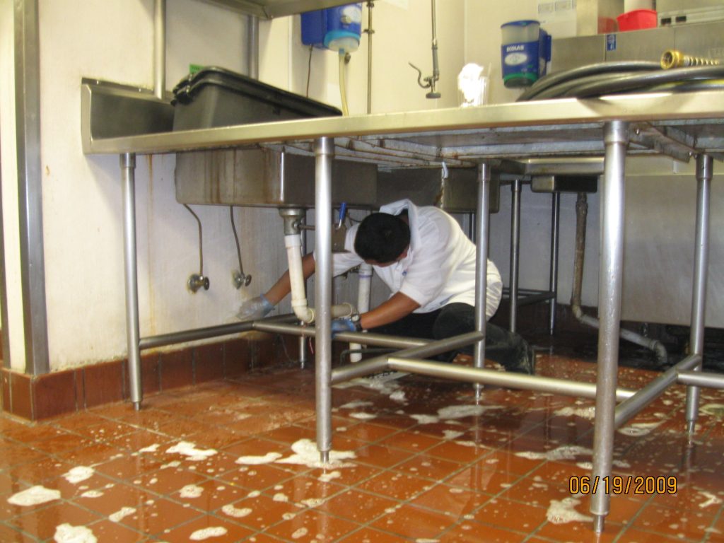 Image of a person cleaning a restaurant kitchen