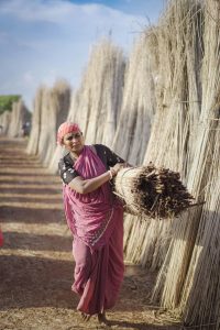 Photo of a woman in India carrying sheaves of straw