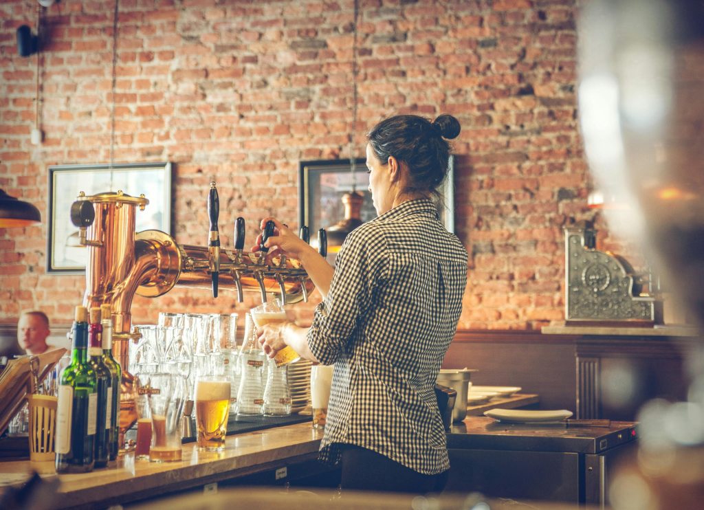 A woman tending bar in a restaurant