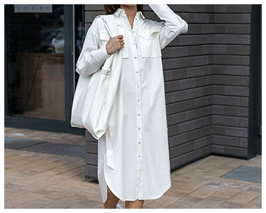 A woman wearing a plain, white button-down shirt dress.