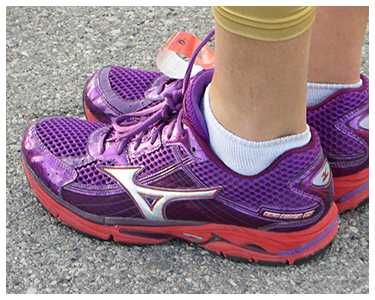 A person wearing purple and pink running shoes.