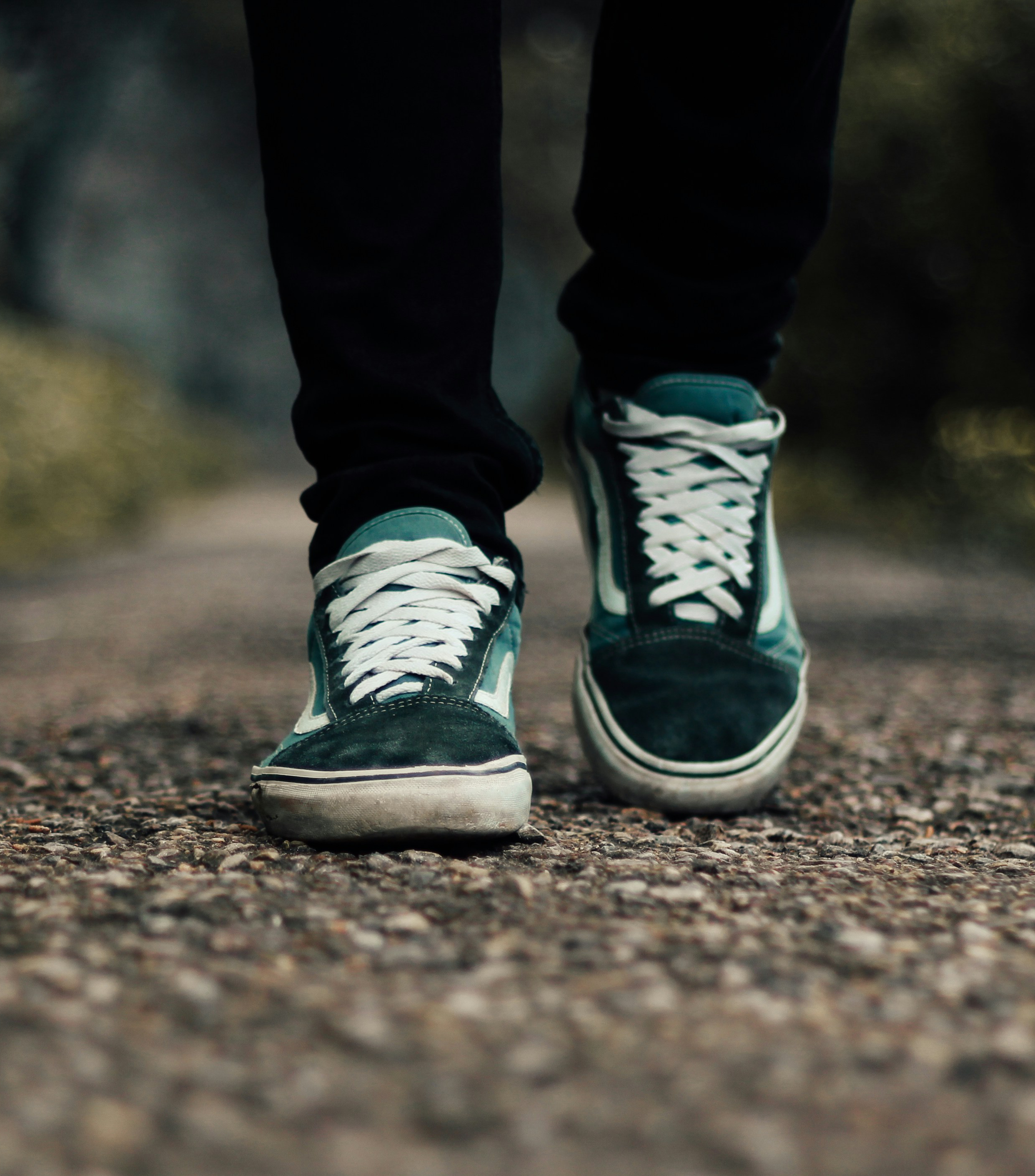 A person's feet while walking on a gravel path.