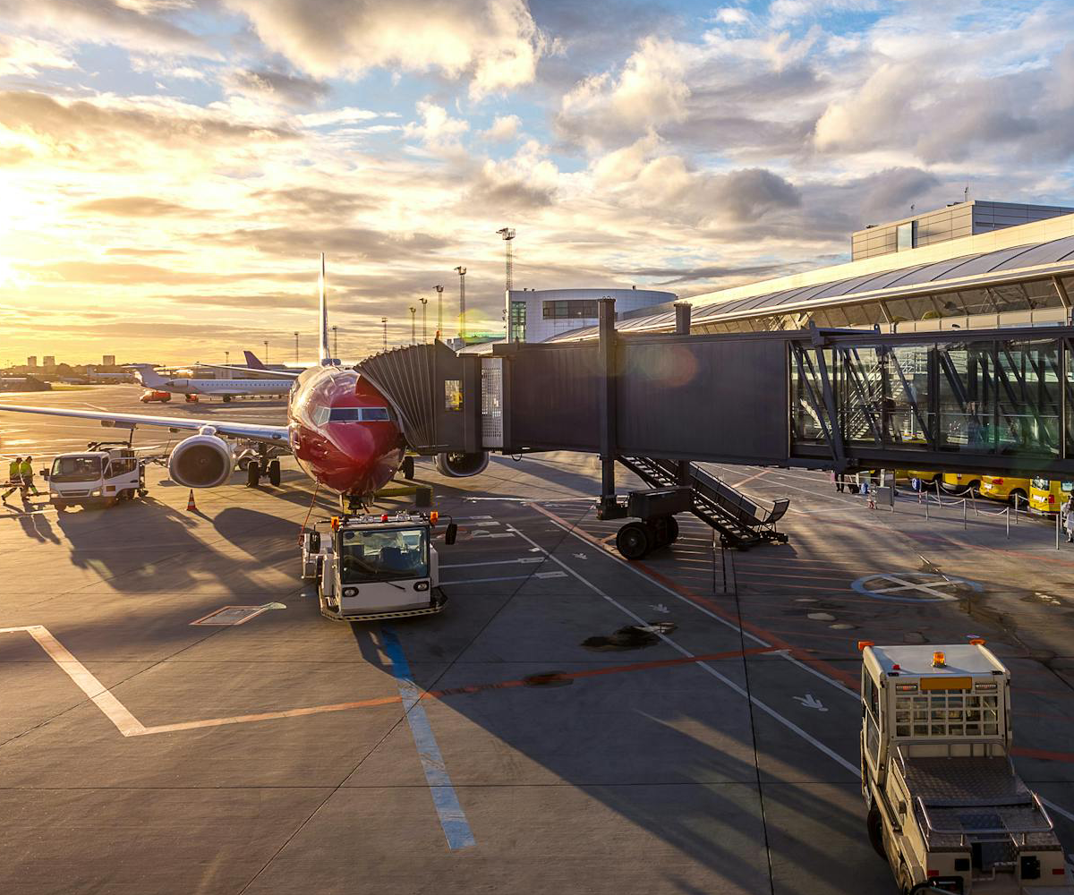 An airplane outside an airport hangar.