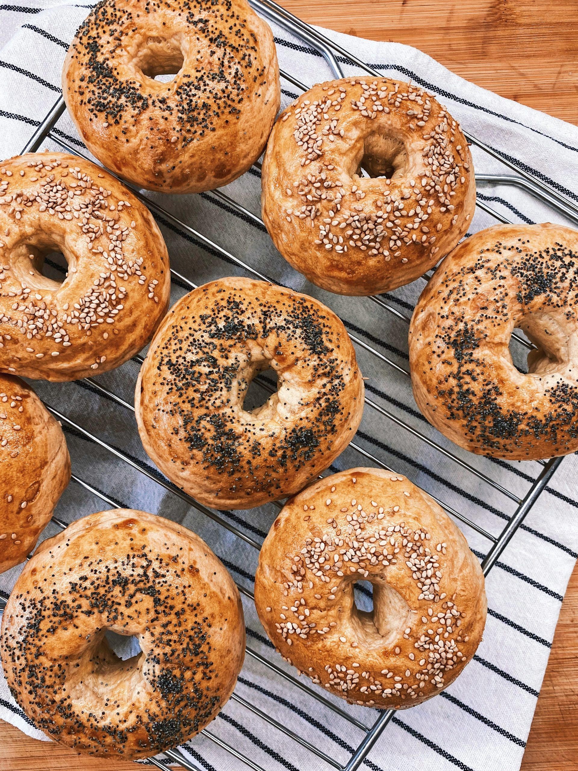 Freshly baked donuts resting on a stainless steel tray on a kitchen counter.