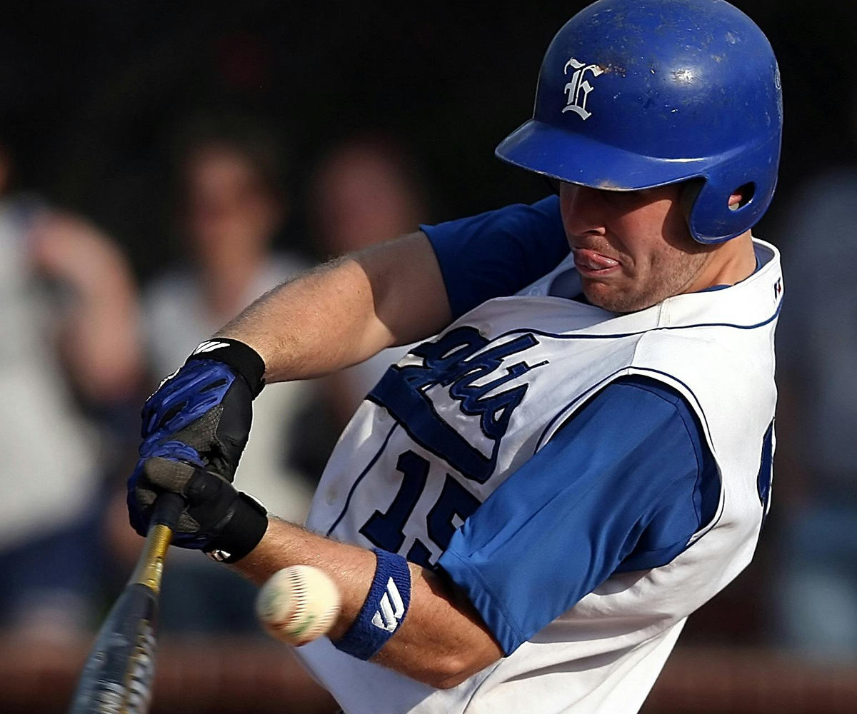 A baseball player hitting the ball with a bat.