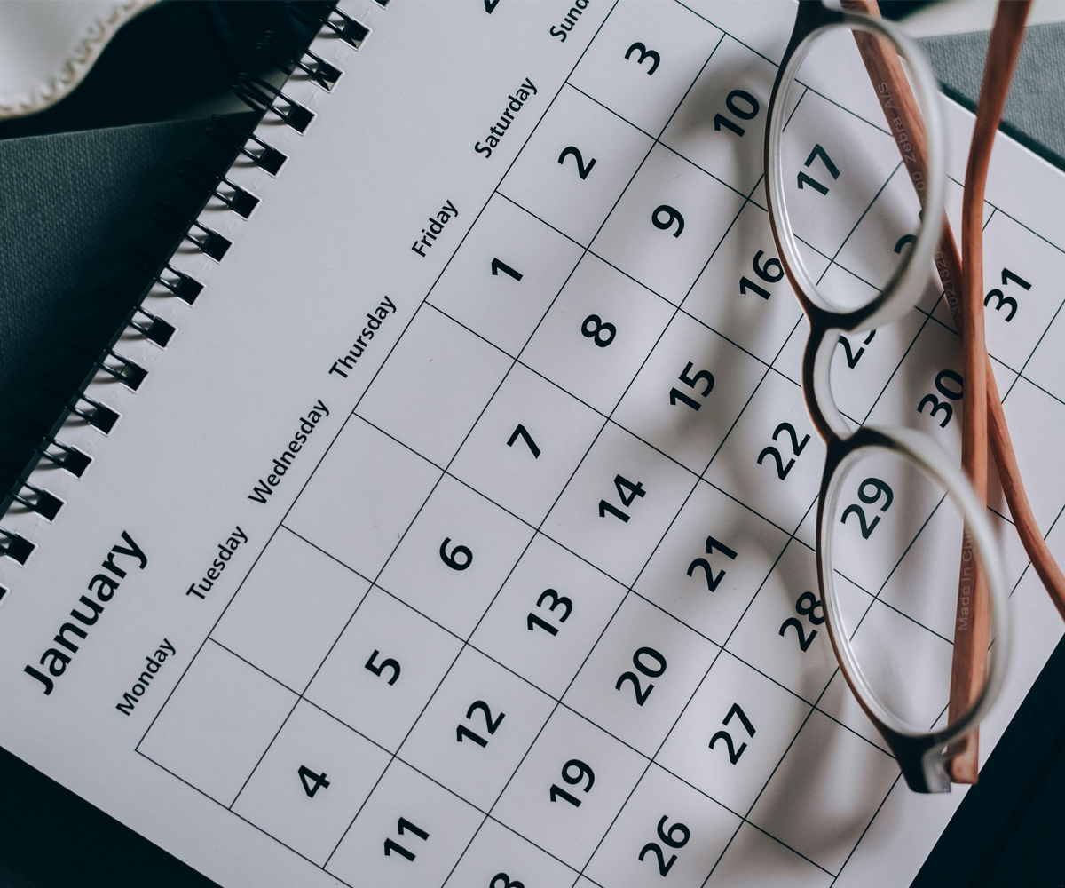 A calendar for the month of January with a pair of glasses on top.