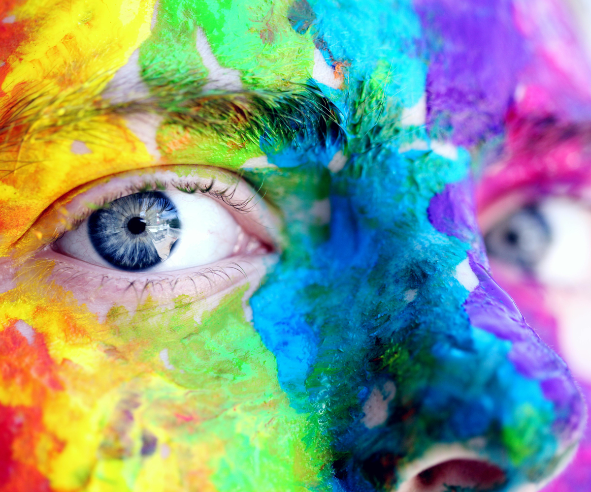 A person wearing colourful face paint.