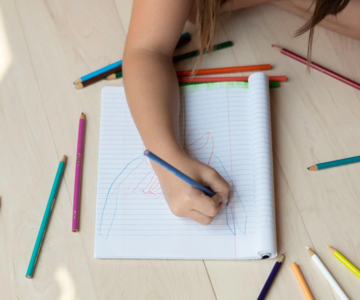 A child colouring with pencil crayons.