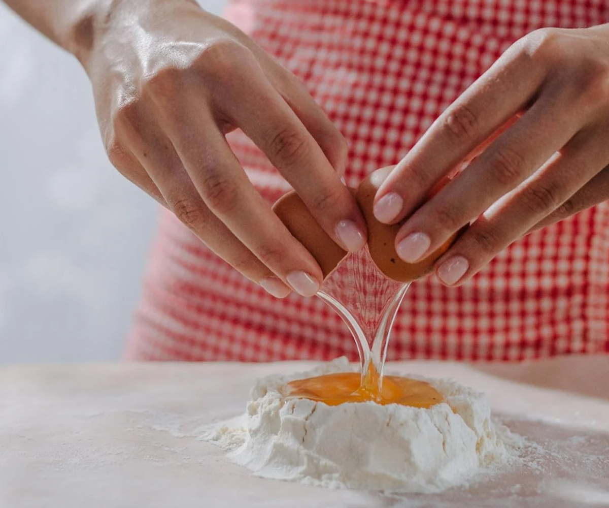A person cracking an egg.