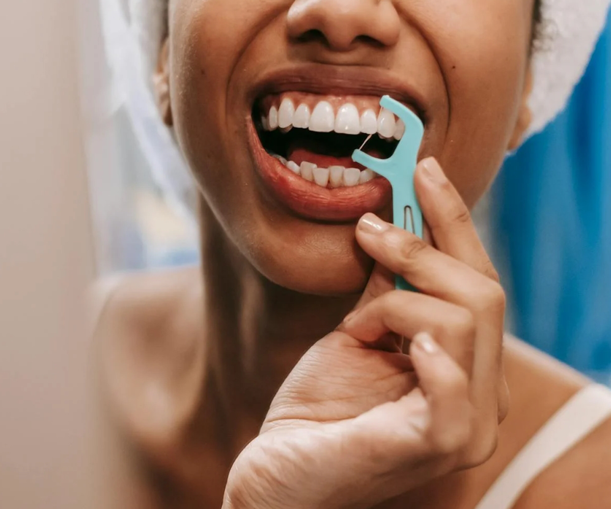 A woman flossing her teeth.