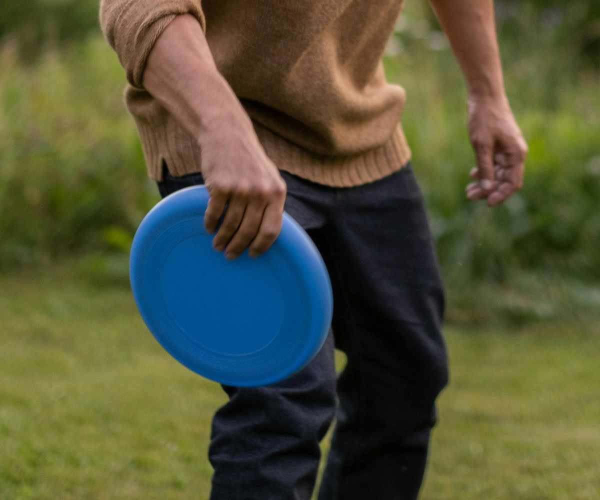 A man holding a blue frisbee.