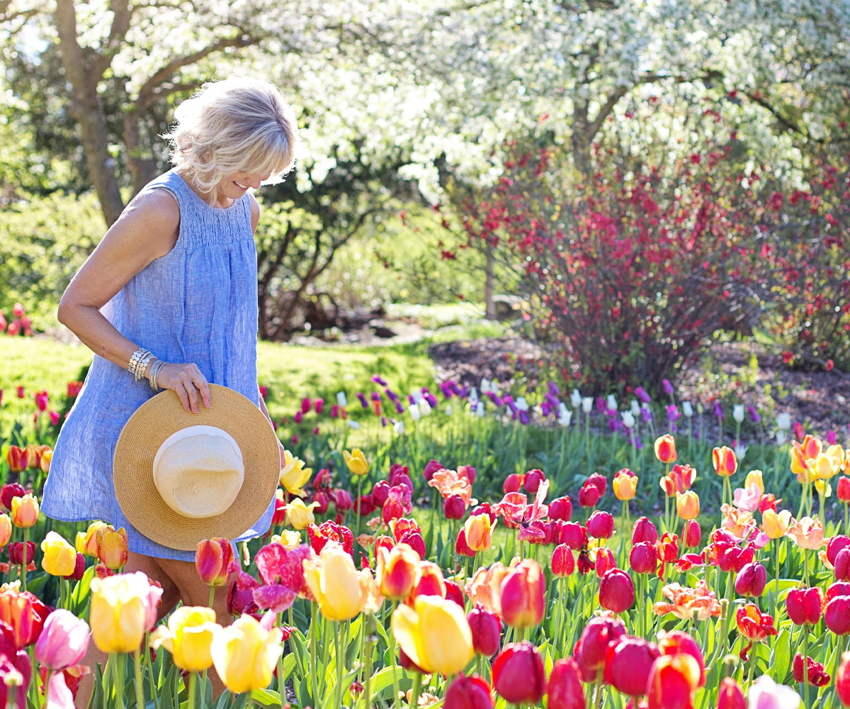 A woman standing in a flower garden.