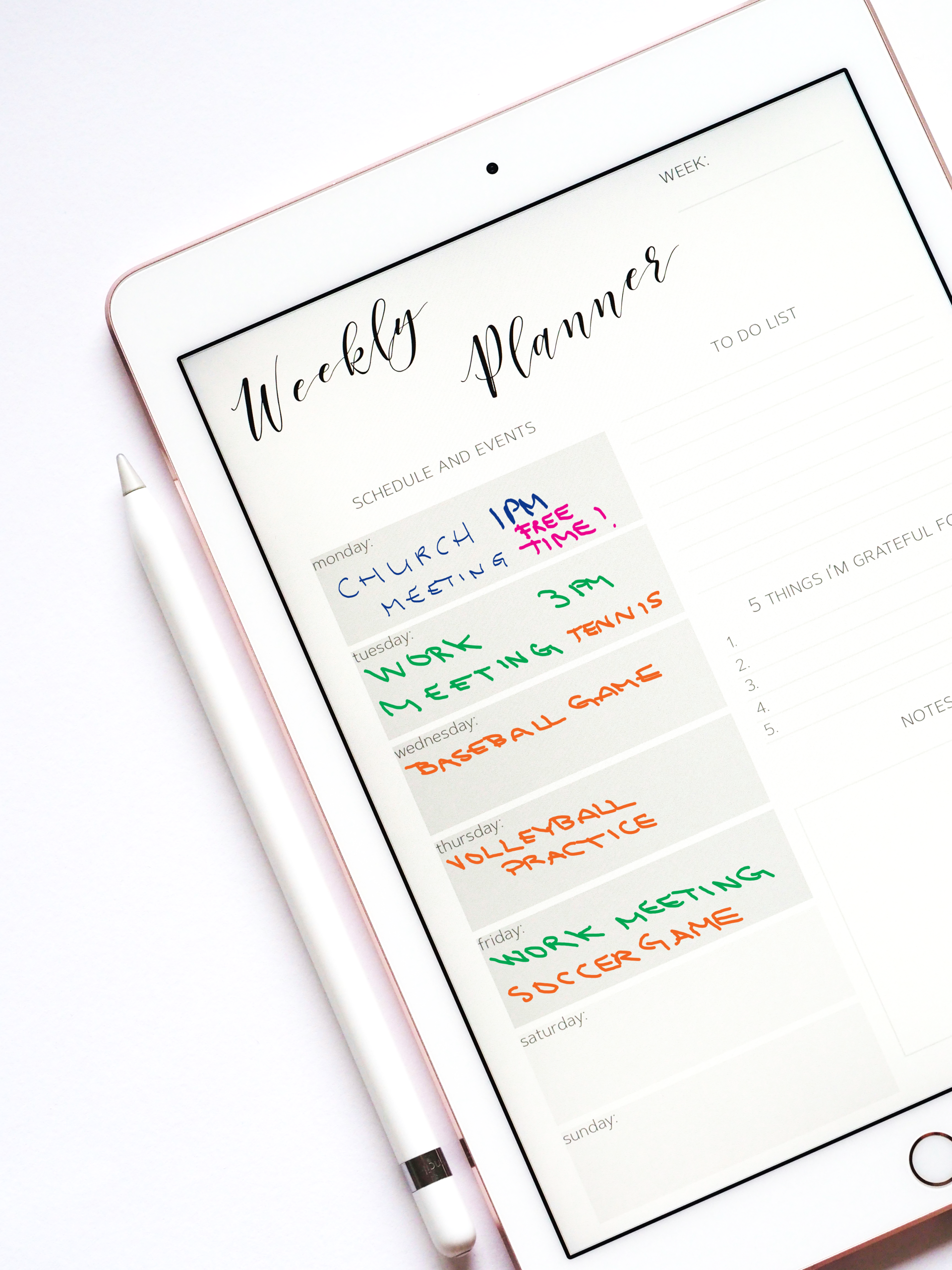 A weekly planner page on an iPad with an Apple pencil next to it. The page has the following written entries: 'church meeting 1PM' and 'free time!' on Monday, 'work meeting 3PM' and 'tennis' on Tuesday, 'baseball game' on Wednesday, 'volleyball practice' on Thursday, 'work meeting' and 'soccer game' on Friday.