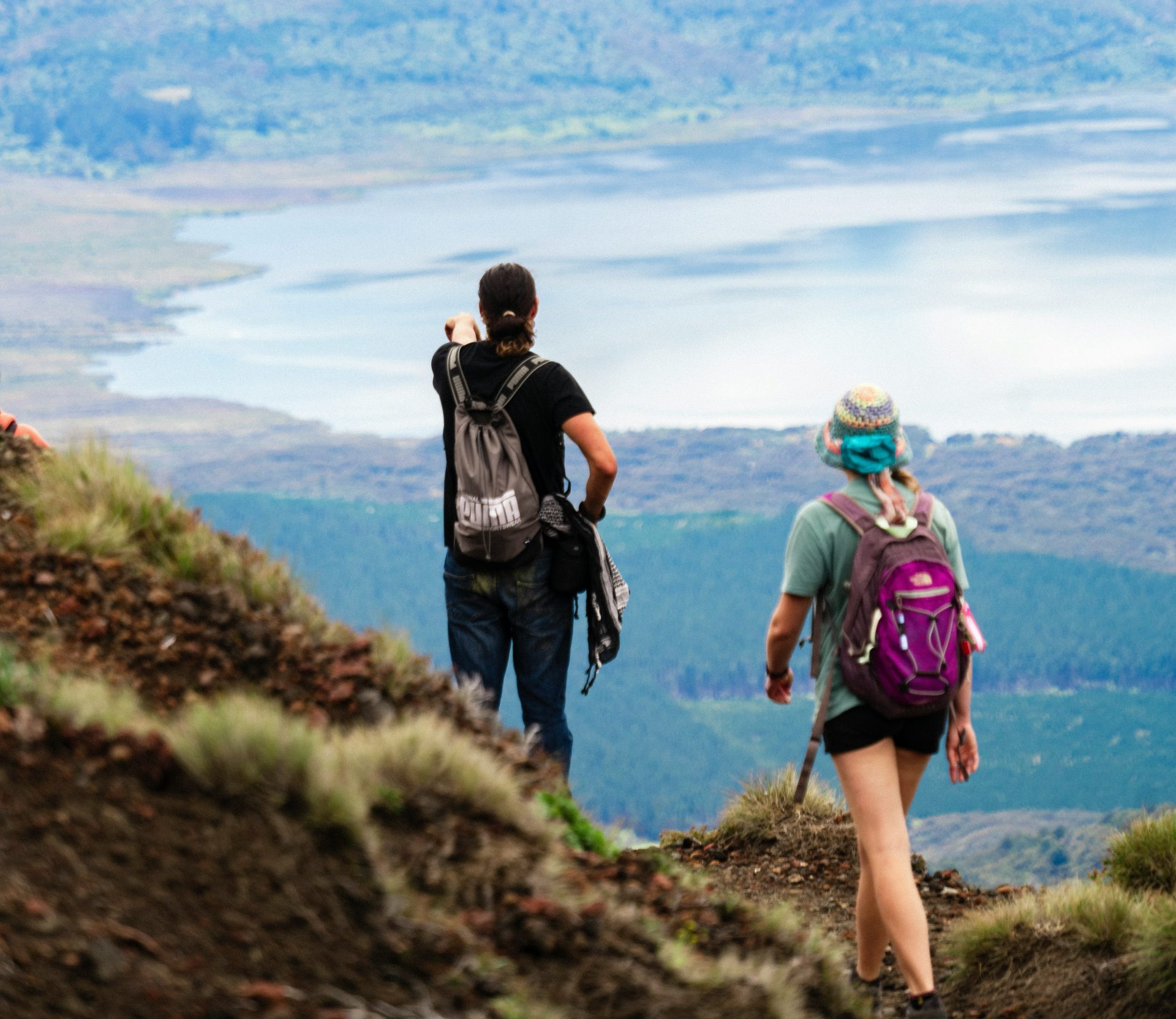A man and a woman hiking by a lake.
