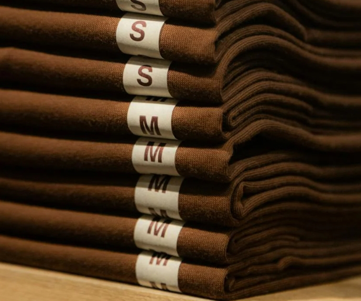 A stack of folded clothes labeled small and medium.