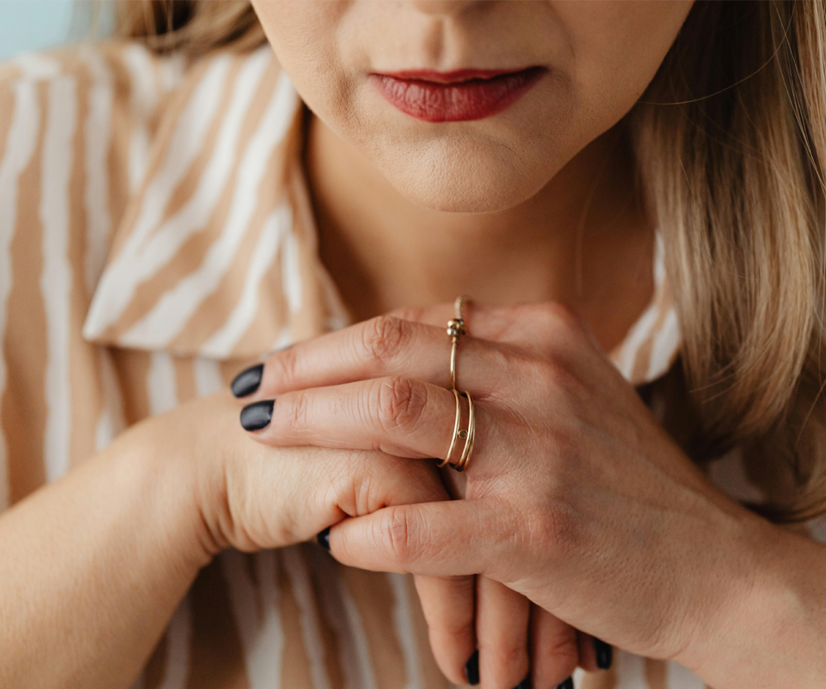 Close up of a woman clasping her hands nervously.