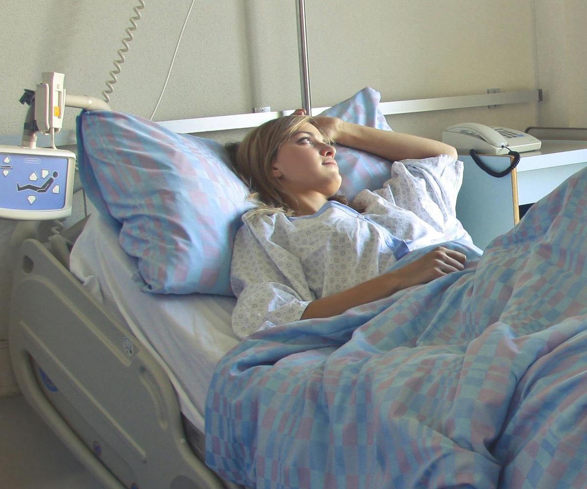 A female patient lying in a hospital bed.