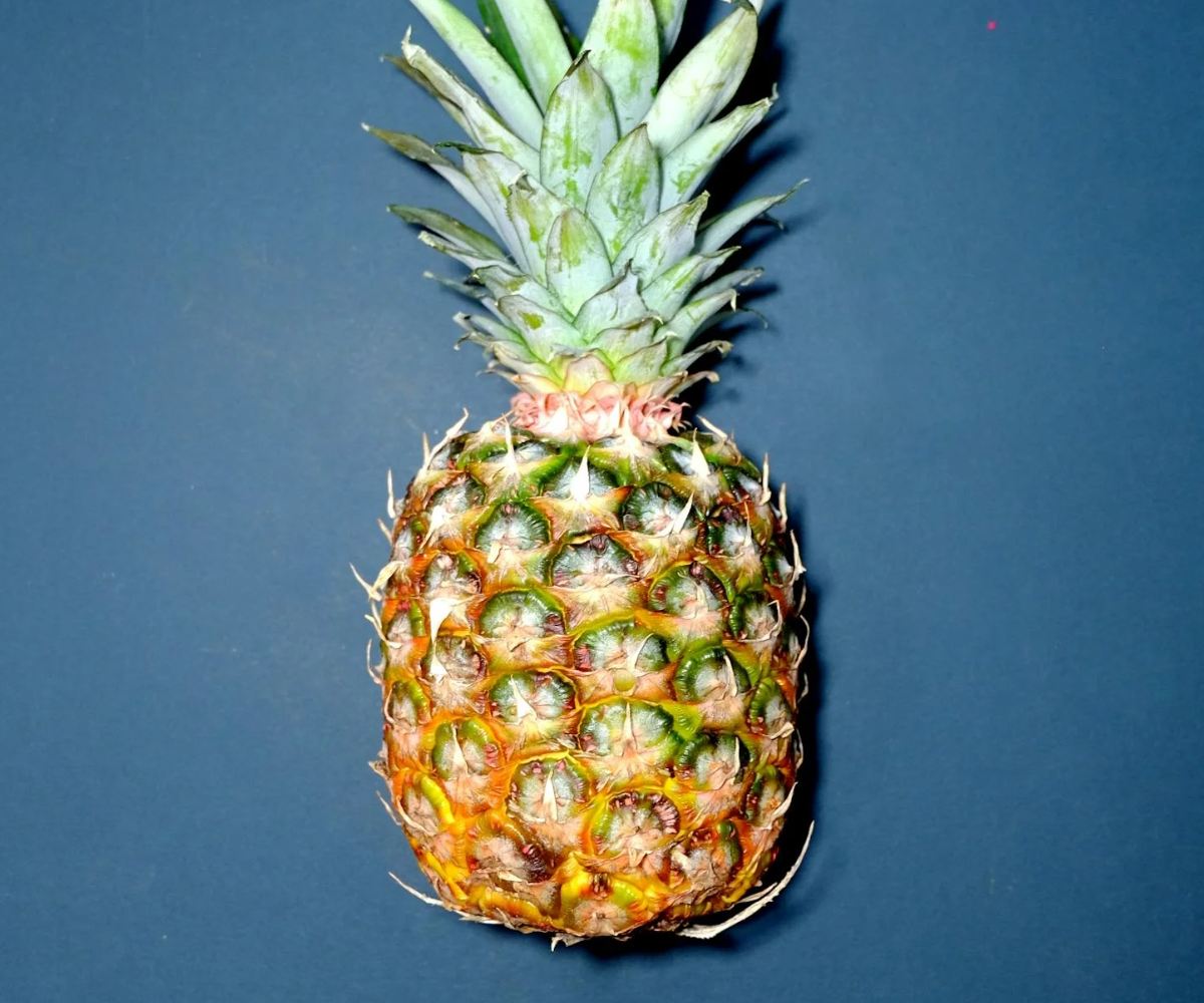 A pineapple on a blue counter.