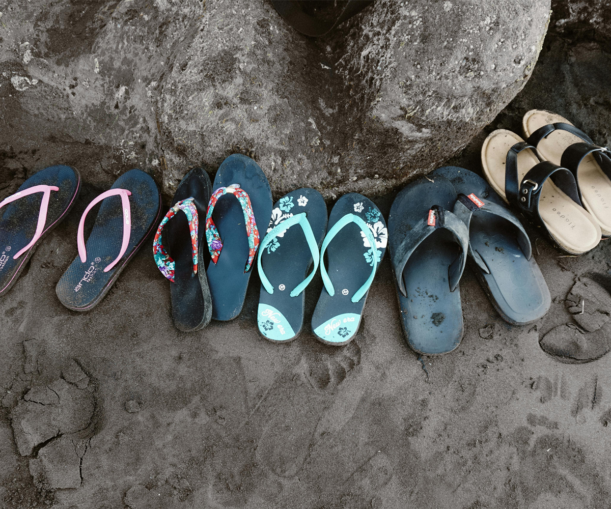 A row of flip flops and sandals.