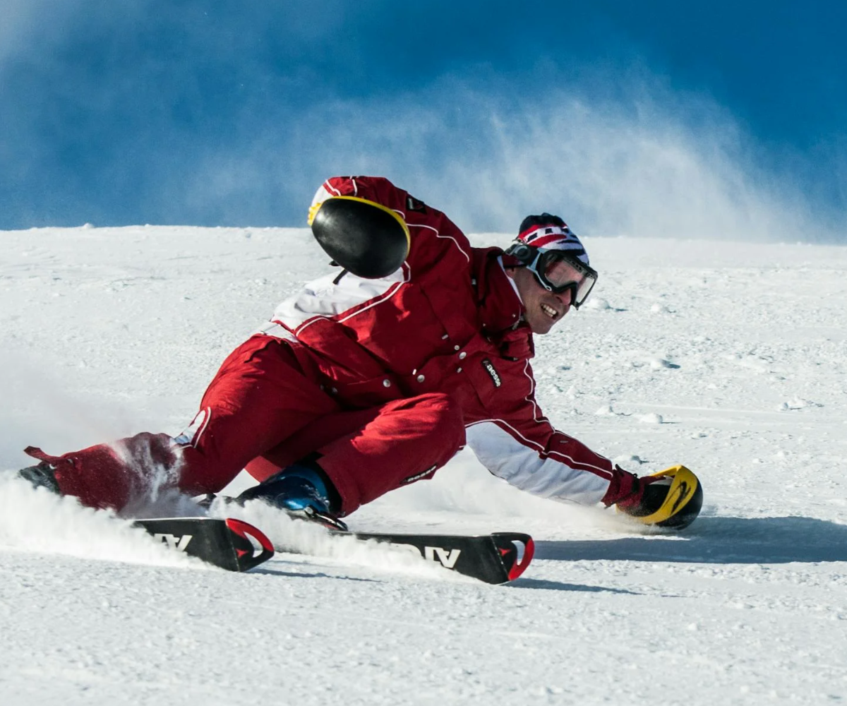 A man wearing a full snowsuit while skiing.