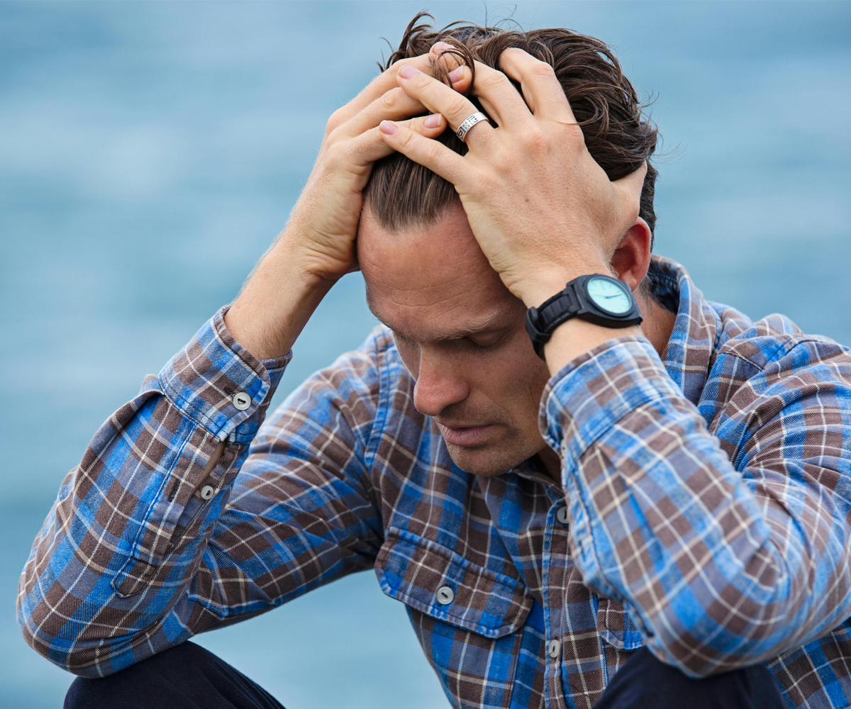 A man sitting with his head in his hands.