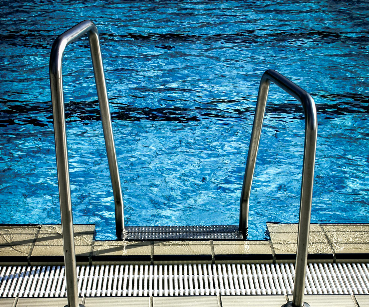 A swimming pool with metal steps going into the water.